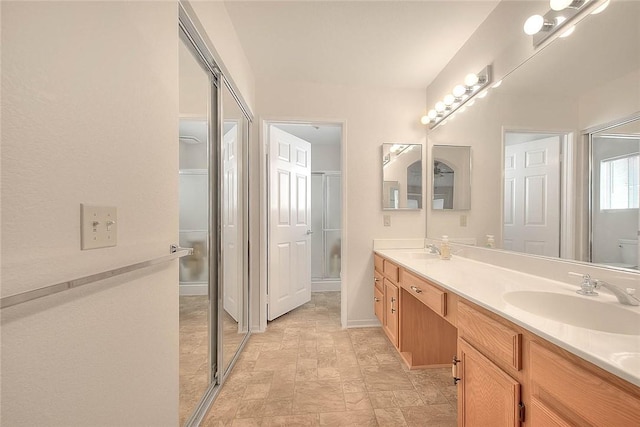 bathroom with walk in shower, vanity, and toilet