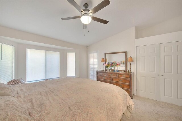 bedroom featuring a closet, ceiling fan, vaulted ceiling, and light carpet