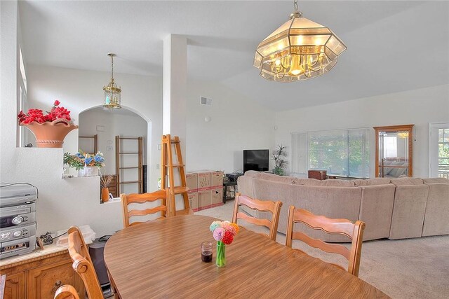 dining area with light colored carpet and lofted ceiling