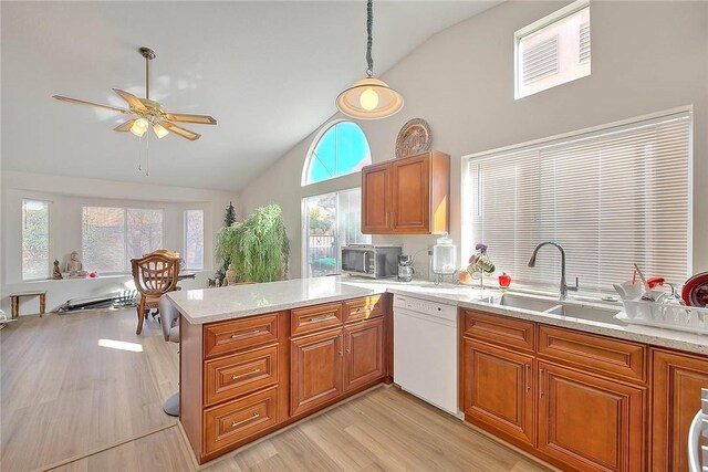 kitchen featuring dishwasher, hanging light fixtures, sink, kitchen peninsula, and vaulted ceiling