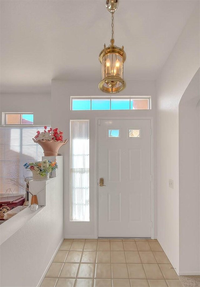 tiled foyer with an inviting chandelier