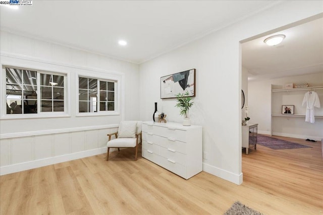 sitting room with ornamental molding and hardwood / wood-style flooring