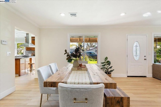 dining room featuring crown molding and light hardwood / wood-style floors