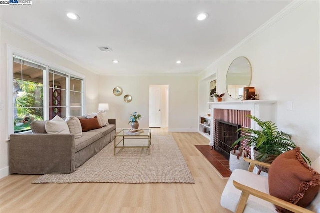 living room with ornamental molding, light hardwood / wood-style floors, and a fireplace