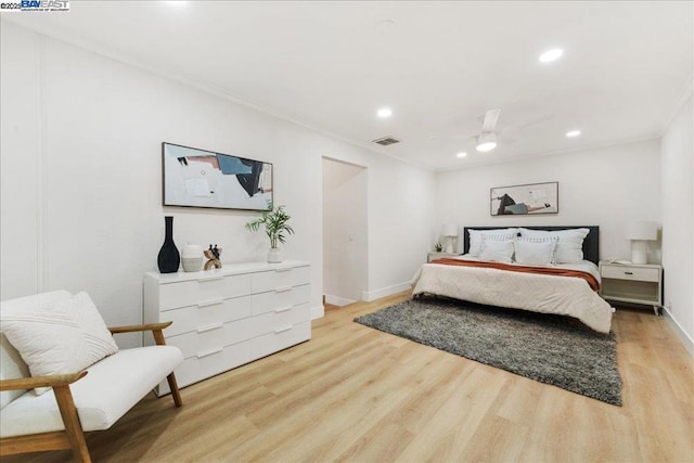 bedroom with ceiling fan, crown molding, and light hardwood / wood-style floors