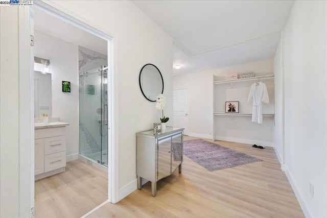 bathroom with a shower with shower door, wood-type flooring, and vanity