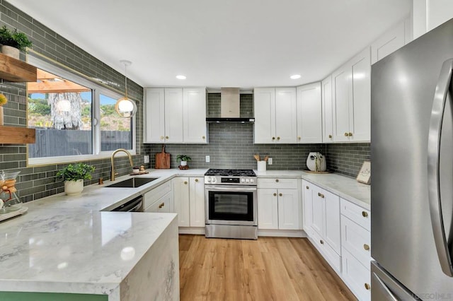 kitchen with wall chimney exhaust hood, sink, white cabinetry, and stainless steel appliances