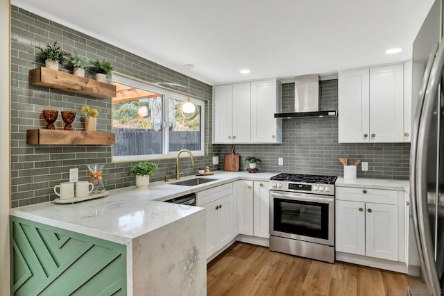 kitchen featuring white cabinets, sink, wall chimney range hood, and stainless steel appliances