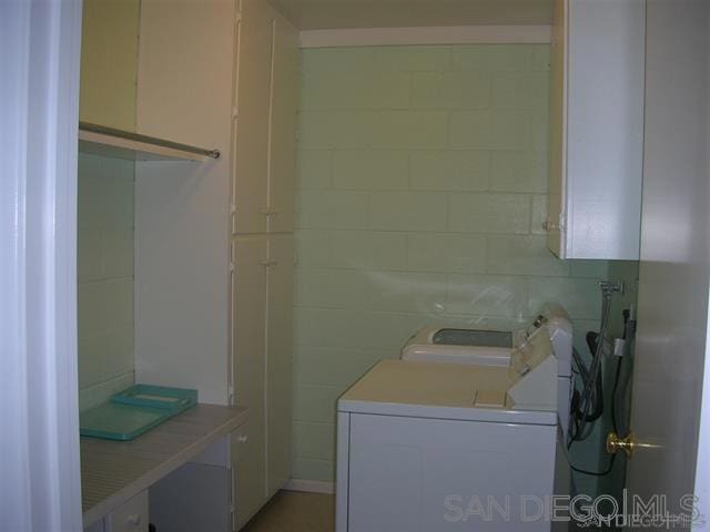 washroom with cabinets and washer and clothes dryer