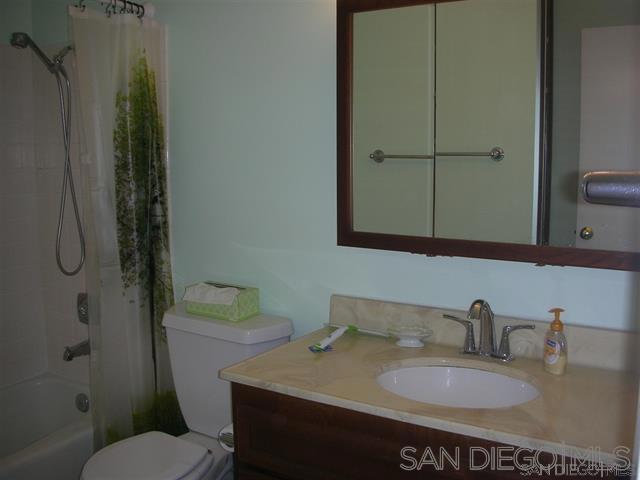 full bathroom featuring toilet, shower / tub combo, and vanity