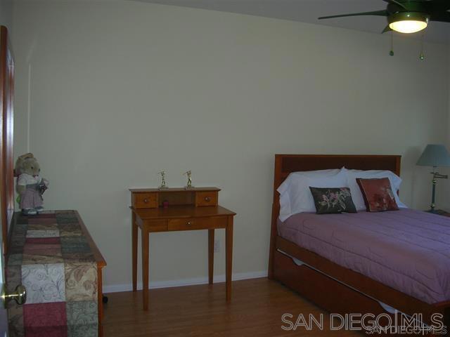 bedroom with ceiling fan and hardwood / wood-style flooring