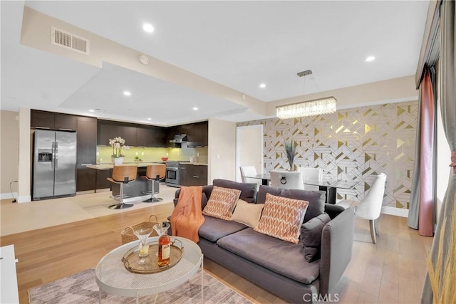 living room with an inviting chandelier and light hardwood / wood-style floors