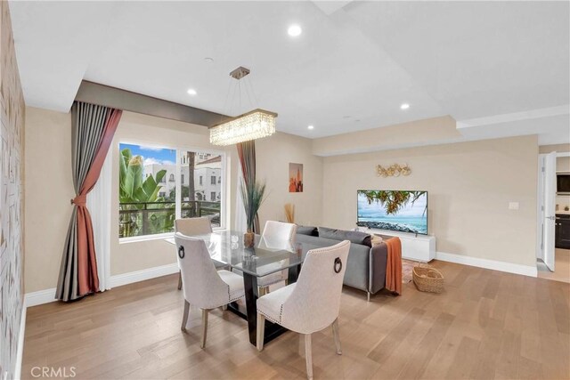 dining area with an inviting chandelier and light hardwood / wood-style flooring