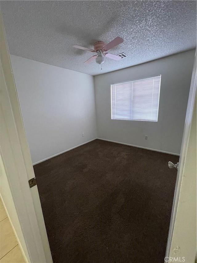 empty room featuring ceiling fan and a textured ceiling