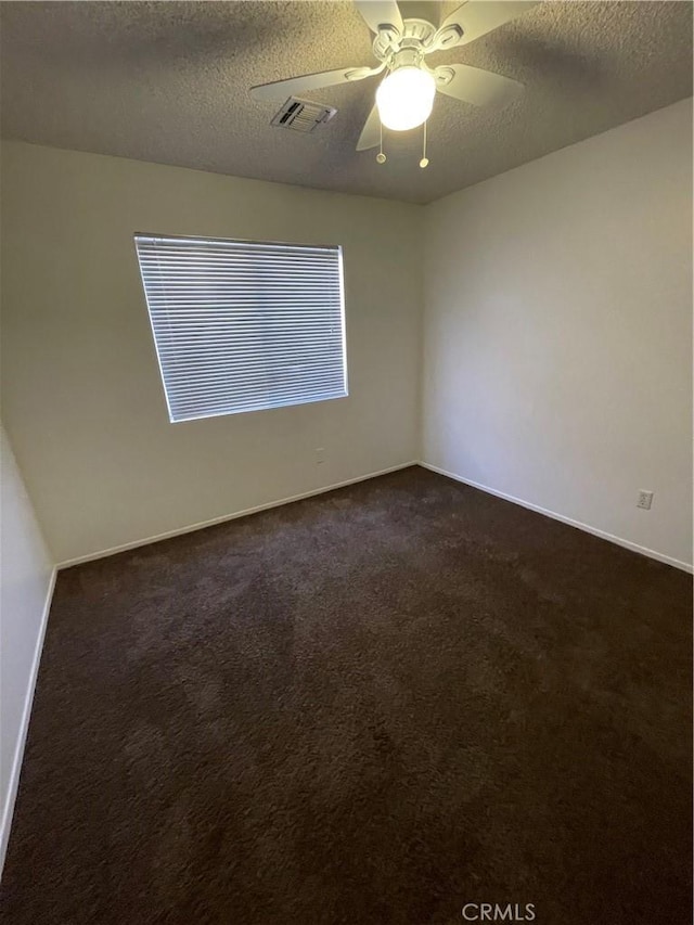 carpeted empty room with ceiling fan and a textured ceiling