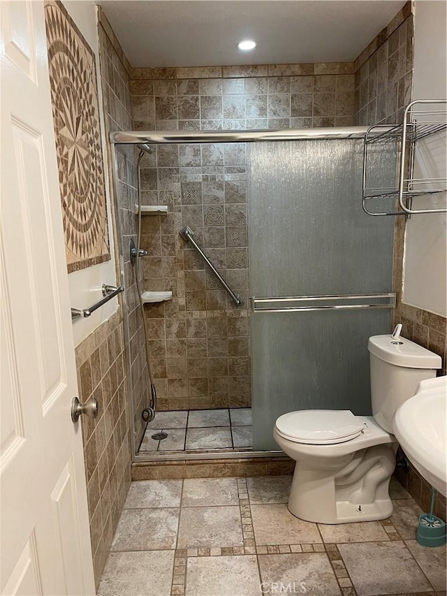 bathroom with toilet and a shower with door