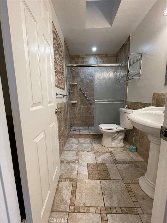 bathroom featuring toilet and a shower with door