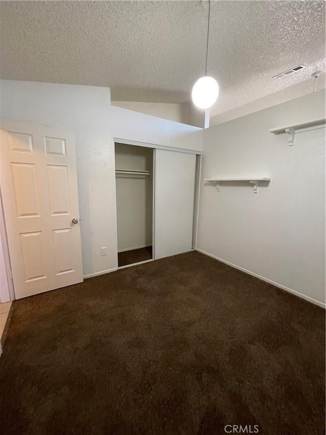 unfurnished bedroom featuring carpet, a closet, and a textured ceiling