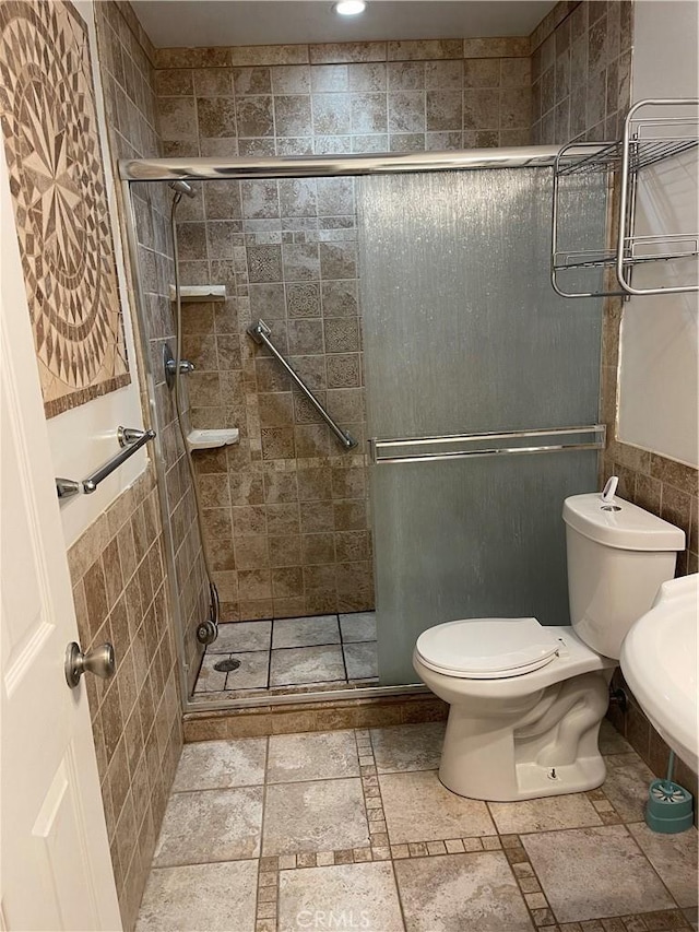 bathroom with toilet and an enclosed shower