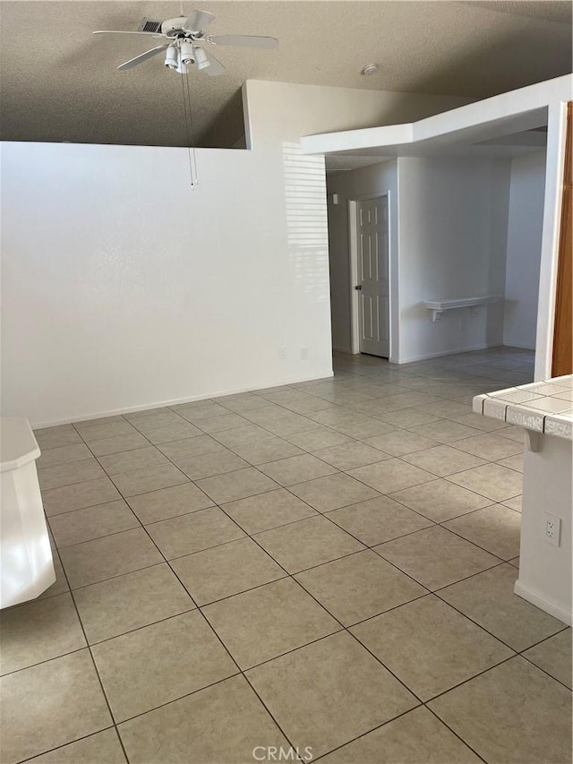 tiled spare room with ceiling fan and lofted ceiling