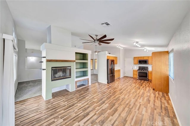 unfurnished living room featuring ceiling fan, lofted ceiling, built in features, and light hardwood / wood-style flooring