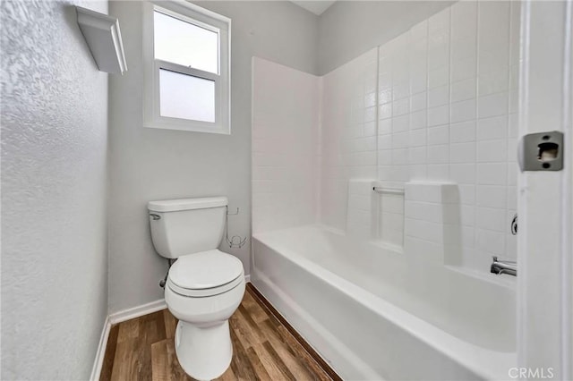 bathroom with toilet, shower / bath combination, and hardwood / wood-style flooring