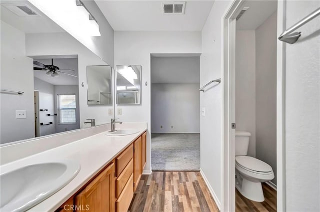 bathroom with ceiling fan, hardwood / wood-style flooring, toilet, and vanity