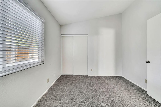 empty room featuring lofted ceiling and carpet floors