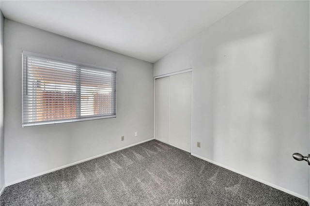 carpeted empty room with lofted ceiling