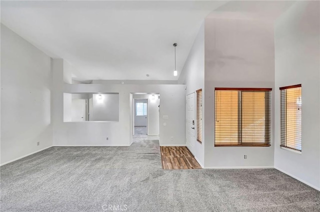 empty room featuring high vaulted ceiling and carpet floors