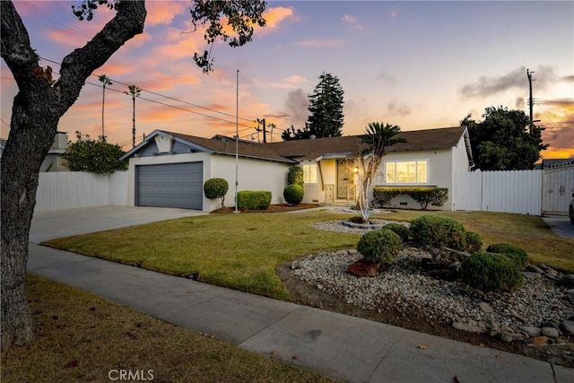 ranch-style home featuring a garage and a lawn