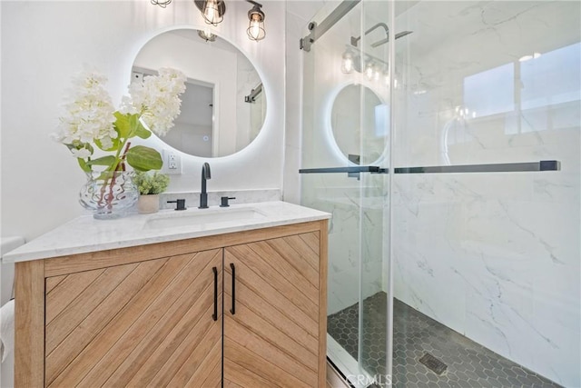 bathroom with vanity and a shower with door