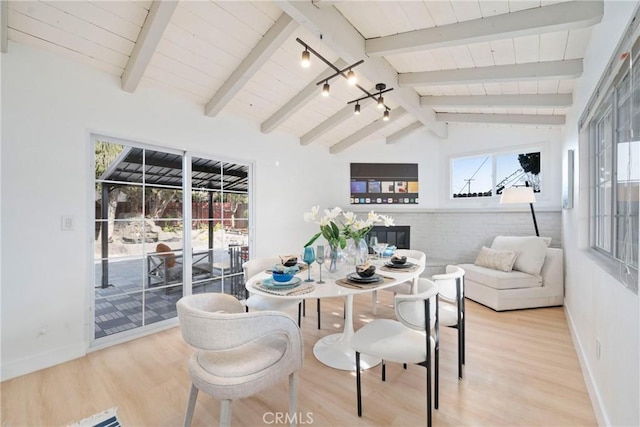 dining space with wood-type flooring, lofted ceiling with beams, rail lighting, and wooden ceiling