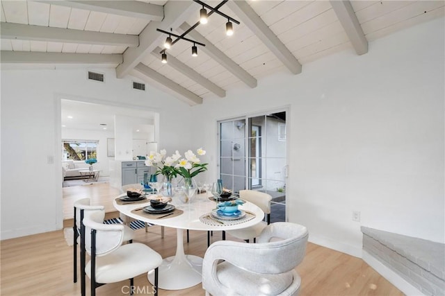 dining room with wood ceiling, rail lighting, lofted ceiling with beams, and light wood-type flooring