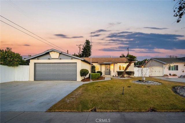 ranch-style home with a garage and a lawn