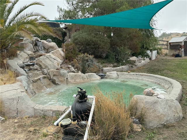 view of swimming pool with a small pond