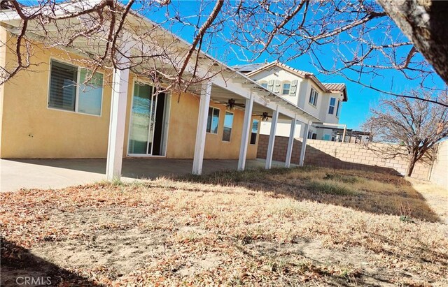 back of property with ceiling fan and a patio