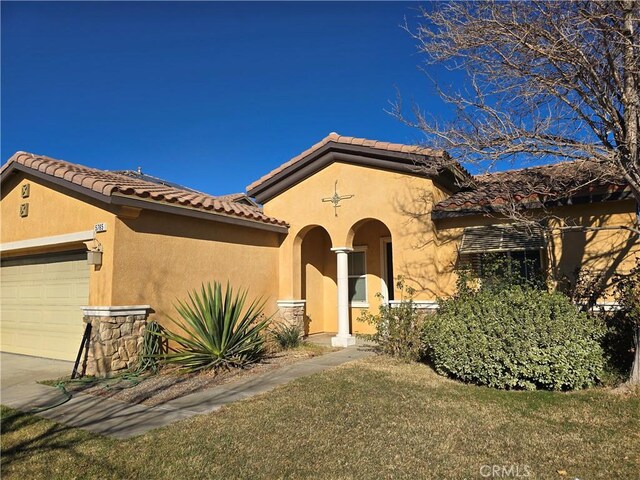 mediterranean / spanish-style home featuring a garage and a front yard