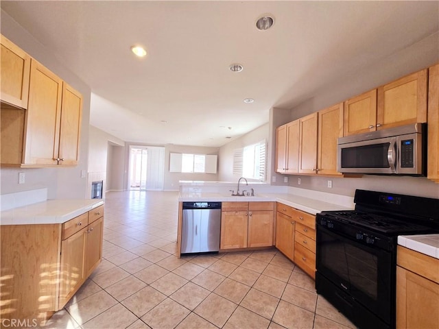 kitchen with appliances with stainless steel finishes, sink, and light brown cabinets