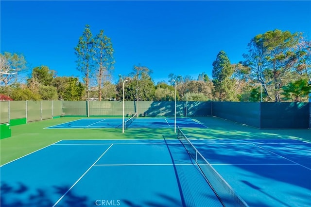 view of tennis court with basketball hoop