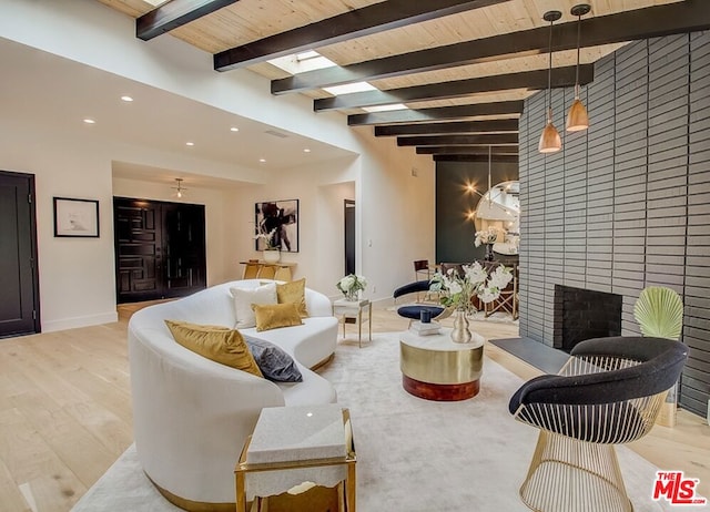 living room featuring a brick fireplace, wooden ceiling, beamed ceiling, and light hardwood / wood-style floors