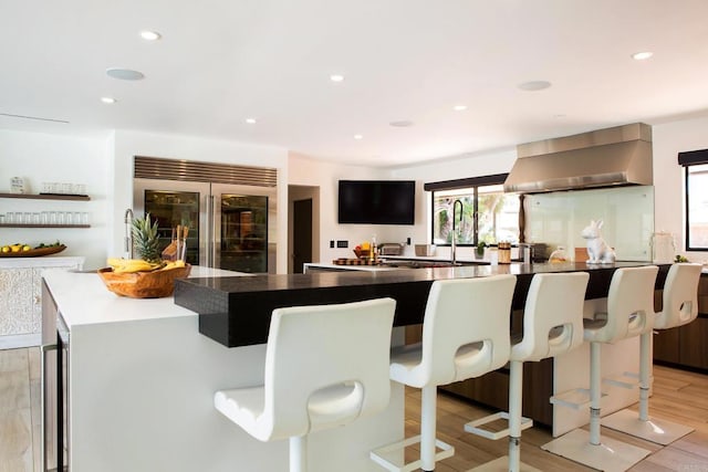 5455 Toyon Rd, San Diego, CA 92115 - kitchen featuring built in fridge, wall chimney exhaust hood, a spacious island, a kitchen bar, and recessed lighting
