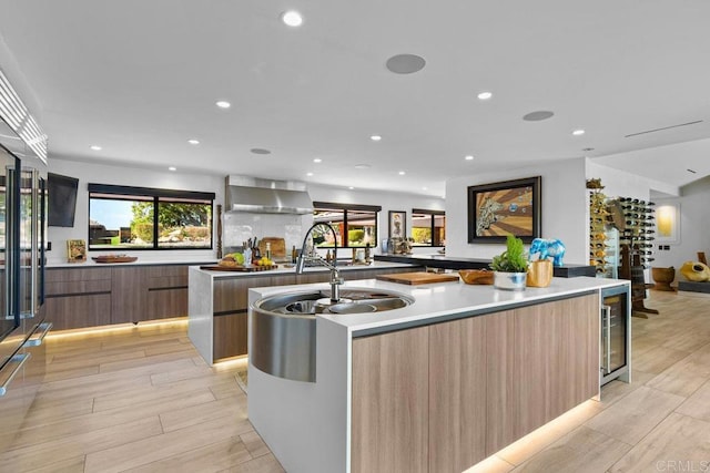 5455 Toyon Rd, San Diego, CA 92115 - kitchen with modern cabinets, wall chimney range hood, a large island with sink, wine cooler, and recessed lighting
