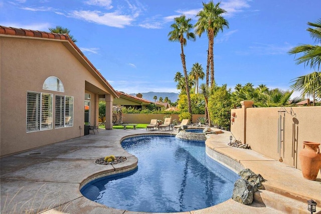 view of pool with an in ground hot tub, a patio area, and a mountain view