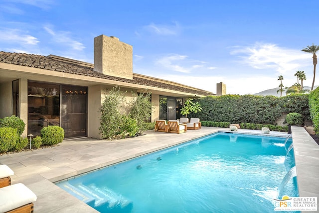 view of swimming pool featuring pool water feature and a patio