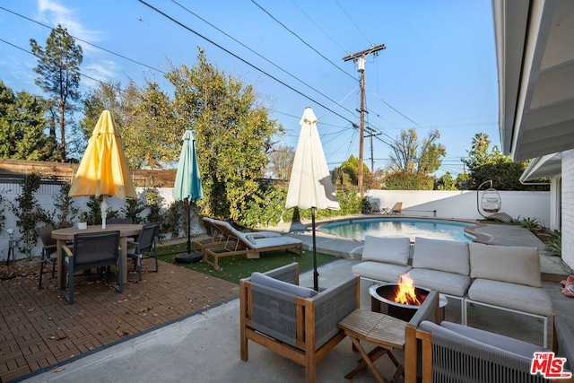 view of patio / terrace featuring a fenced in pool and a fire pit