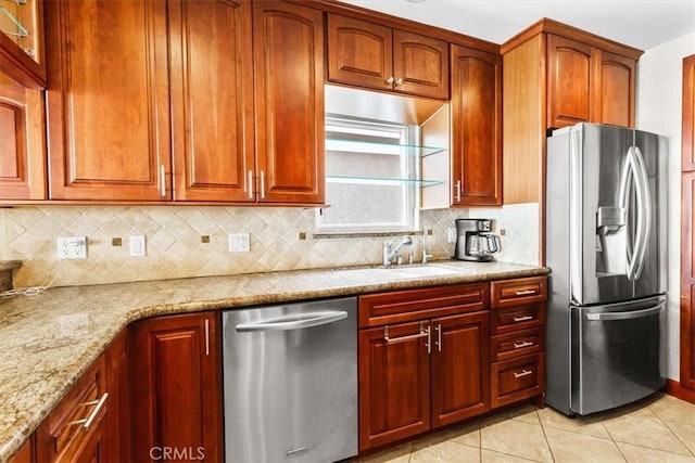 kitchen featuring decorative backsplash, sink, appliances with stainless steel finishes, light tile patterned floors, and light stone counters