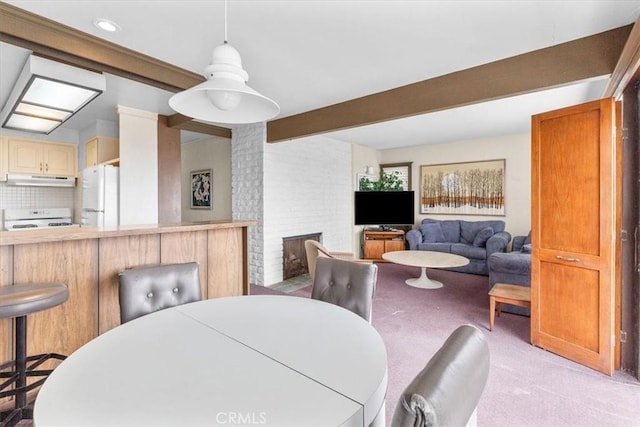 carpeted dining room featuring a brick fireplace and beamed ceiling