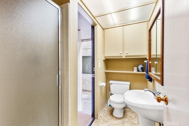 bathroom featuring an enclosed shower, sink, and toilet