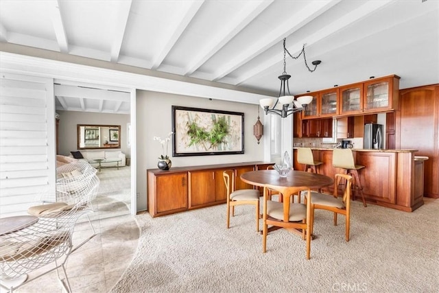 carpeted dining room with a notable chandelier and beamed ceiling